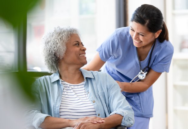 Nurse smiling at patient in a wheelchair
