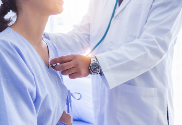 Doctor checking the heart of a female patient