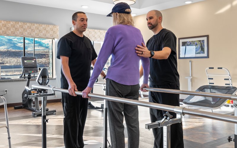 Physical therapists helping a patient walk