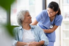 Nurse smiling at patient in a wheelchair