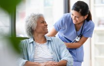 Nurse smiling at patient in a wheelchair