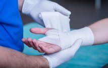 Un médico vendando una herida en el brazo de un paciente.